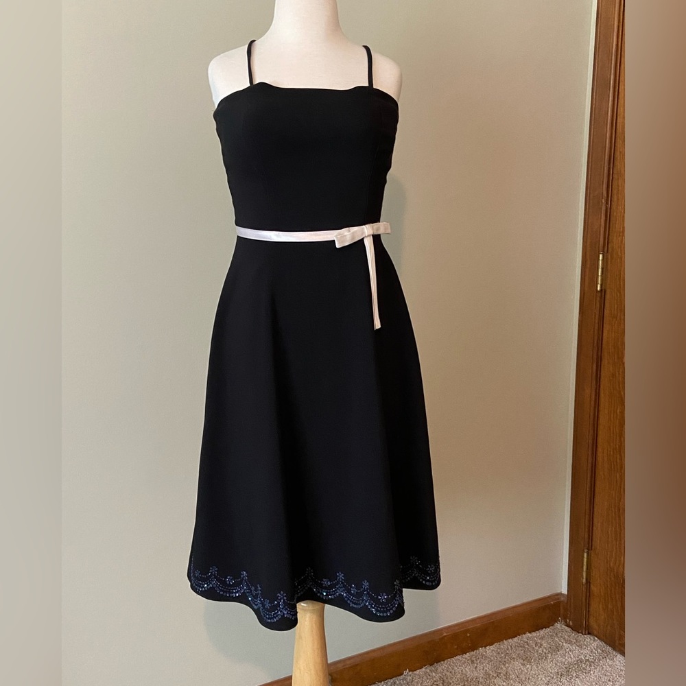 black cocktail dress with white bow and small blue detailing